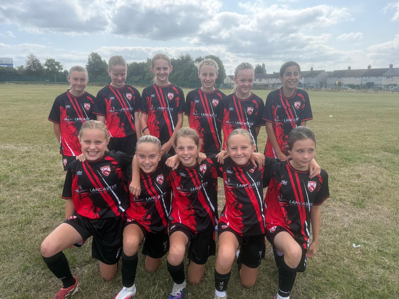 Morecambe Girls FC squad posing together on the pitch